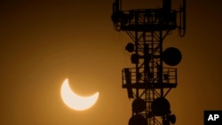 FILE - A cell phone tower is seen during a partial solar eclipse in Rawalpindi, Pakistan, Oct. 25, 2022. Internet services were slowed in country on Sunday and access to major social media platforms blocked during a rare online opposition rally.