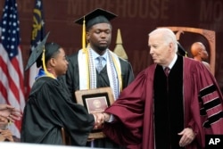 President Joe Biden, right, congratulates salutatorian Dwayne Allen Terrell II, left, as valedictorian DeAngelo Jeremiah Fletcher looks on at the Morehouse College commencement, May 19, 2024, in Atlanta, Georgia.