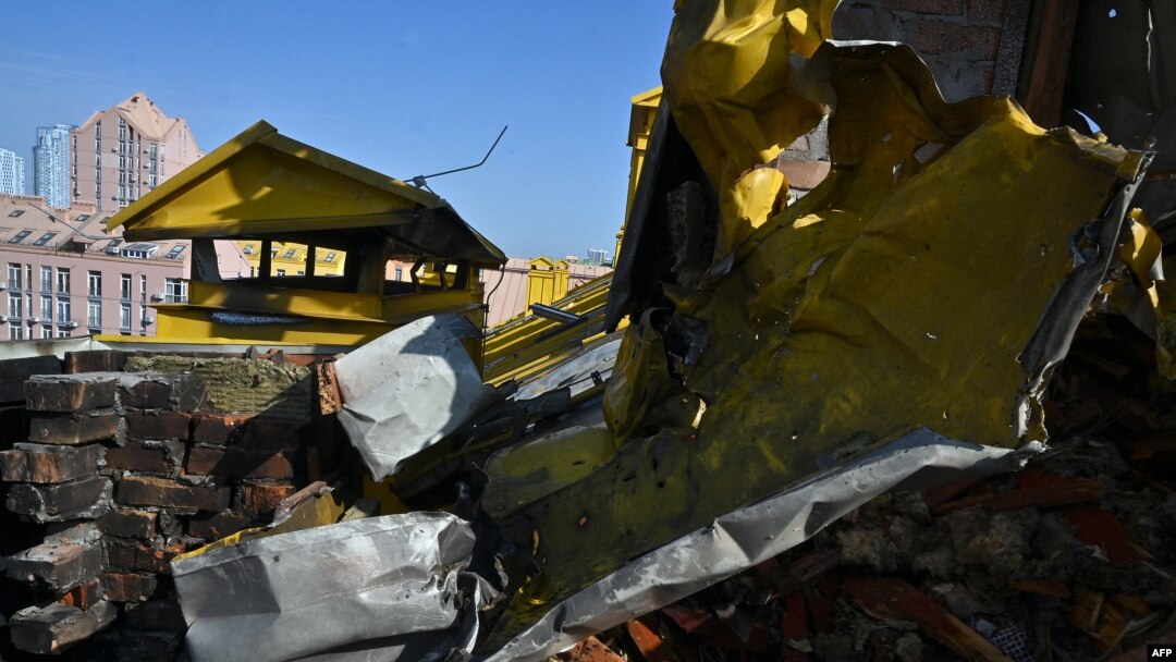 A photograph shows a hole in a roof of a multistore building damaged as a result of falling debris after a massive drone attack overnight in Kyiv on May 20, 2023.