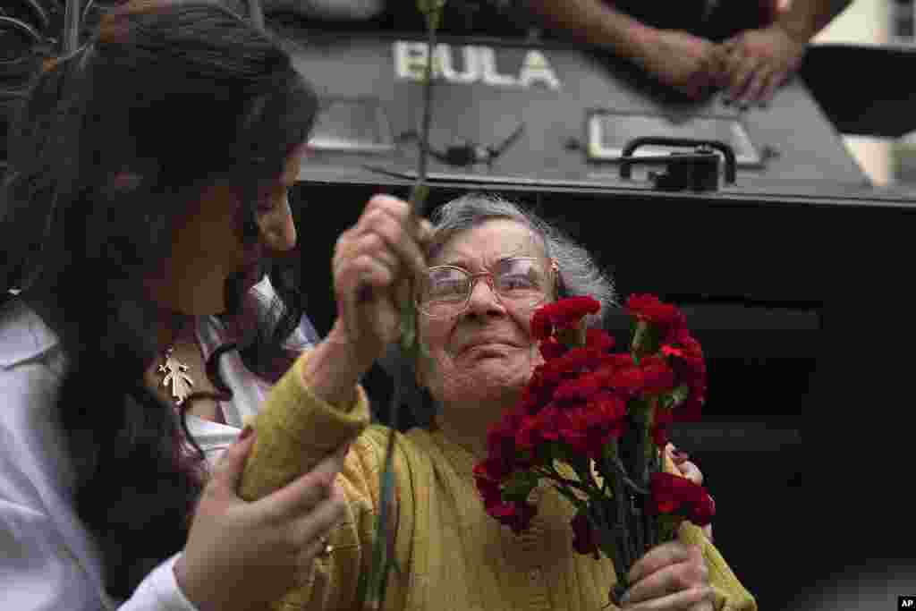 Селест Каеиро (90) држи црвени каранфили во Лисабон, дел од прославите на годишнината од Револуцијата на каранфилите.