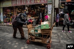 资料照：一名拾荒老人走过北京街头。（2021年3月5日）