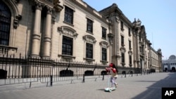 ARCHIVO - Una niña juega frente al palacio de gobierno en Lima, Perú, el viernes 9 de diciembre de 2022. 