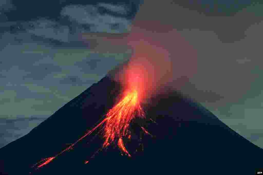 Mount Merapi spews lava during an eruption before dawn as seen from Kaliurang Selatan, central Java, Indonesia.