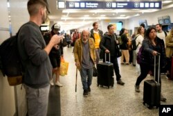 With the aid of a cane, Angel Gomez walks through the Jorge Newbery international airport, commonly known as Aeroparque, in Buenos Aires, Argentina, April 6, 2023.