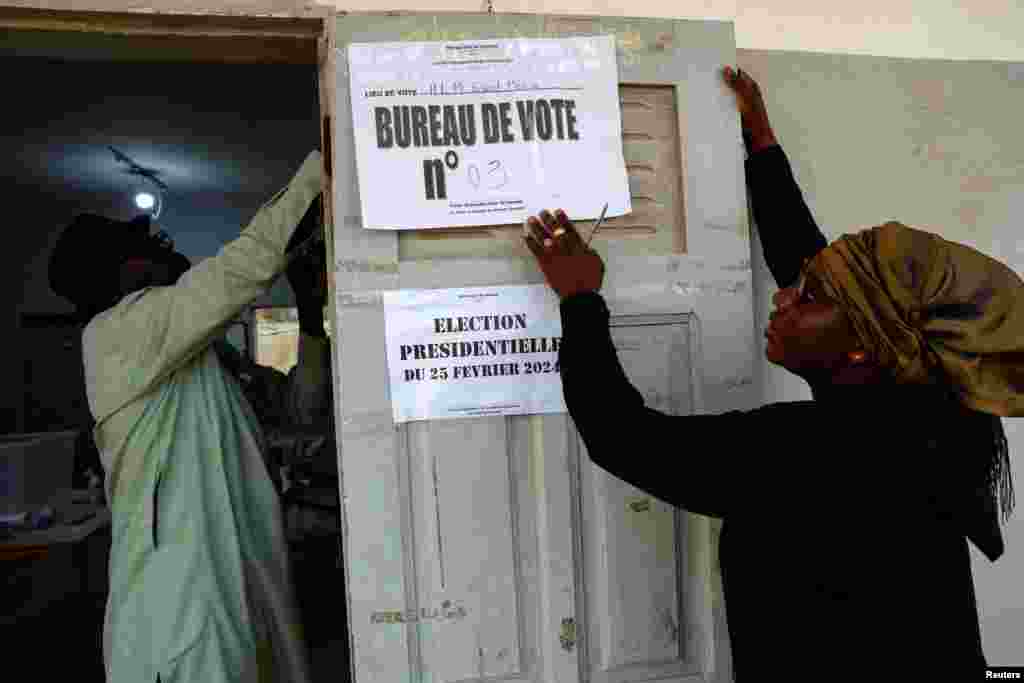 Electoral workers put up a sign at the polling station at Ecole HLM Grand Medine during the presidential election in Dakar, Senegal, March 24, 2024. 