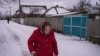 Una mujer camina sobre la nieve en Nova Kozacha, Ucrania, el 14 de febrero de 2023. Esta pequeña aldea fronteriza ha perdido más del 75 % de su población desde el comienzo de la guerra. Pocas personas han regresado, muchos temen que Rusia vuelva a atacar. [Foto: Yan Boechat, VOA]