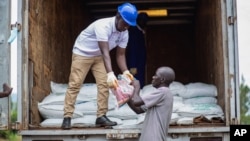FILE - Workers unload agricultural products from a truck in Uganda on Oct. 11, 2022. The U.S. State Department has warned investors of the financial and reputational risks posed by endemic corruption in Uganda. (Business Wire via AP)