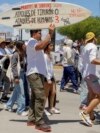 Locals march to protest the disappearance of foreign surfers in Ensenada, Mexico, May 5, 2024. Mexican authorities said Friday that three bodies were recovered in an area of Baja California near where two Australians and an American had gone missing.