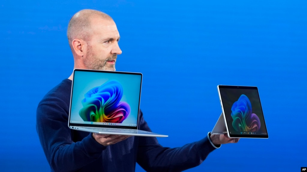 Brett Ostrum, Microsoft corporate vice president of Surface, holds up the new Surface Laptop and Surface Pro with built-in AI at an event of the company's AI assistant, Copilot, Monday, May 20, 2024, in Redmond, Wash. (AP Photo/Lindsey Wasson)