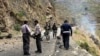 FILE - Security personnel inspect the site of a suicide attack near Besham city in the Shangla district of Khyber Pakhtunkhwa province, Pakistan, on March 26, 2024. 