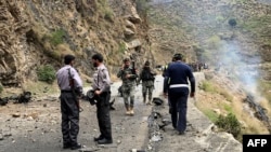 FILE - Security personnel inspect the site of a suicide attack near Besham city in the Shangla district of Khyber Pakhtunkhwa province, Pakistan, on March 26, 2024. 