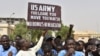 FILE - Protesters react as a man holds up a sign demanding U.S. Army soldiers leave Niger without negotiation during a demonstration in Niamey, on April 13, 2024. The U.S. will withdraw its troops from Niger, a source familiar with the matter said on Friday.