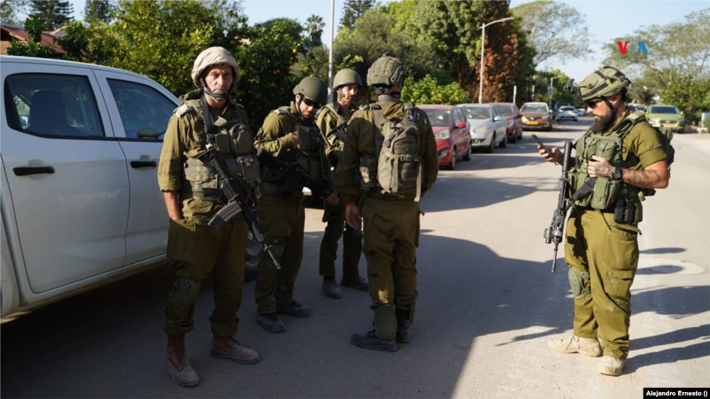 Varios soldados del ejército de Israel conversan en la entrada del kibutz Holit, atacado durante la invasión Hamás hace casi 20 días.