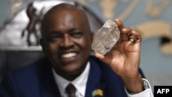 Botswana's President Mokgweetsi Masisi holds a large diamond discovered in his country, at his office in Gaborone, Aug. 22, 2024.