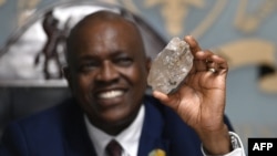 Botswana's President Mokgweetsi Masisi holds a large diamond discovered in his country, at his office in Gaborone, Aug. 22, 2024.