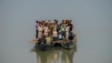 Nhân viên phòng phiếu và nhân viên an ninh đi thuyền nhỏ qua sông đến phòng phiếu ở vùng sâu vùng xa bên kia sông Brahmaputra vào đêm bầu cử quốc hội ở vùng Đông Bắc Ấn Độ, 18 tháng Tư, 2024.