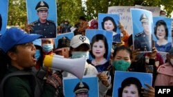 FILE - Protesters hold placards of Cambodia's Prime Minister Hun Sen and his wife Bun Rany as they call for benefits to help workers after their textile factory was shuttered related to the COVID-19 coronavirus pandemic in Phnom Penh on July 29, 2020.