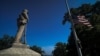 资料照：纽约哈德逊河畔橡树山公墓里一座美国内战联邦军士兵塑像旁飘扬着降半旗的美国国旗。（2023年5月29日）