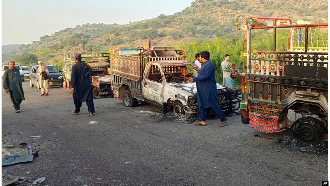 Orang-orang melihat kendaraan yang dibakar oleh kelompok bersenjata setelah membunuh penumpang, di jalan raya di Musakhail, sebuah distrik di Provinsi Baluchistan di Pakistan barat daya, Senin, 26 Agustus 2024. (Foto: AP/Rahmat Khan)