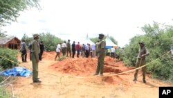 FILE: Police officers stand near a cordon at the scene where police are exhuming bodies of victims of Christian cult that has led to death of dozens of followers on the outskirts of Malindi, Kenya, April 25, 2023. 