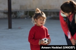 Naya, 4, is seen playing with a ball while talking to a UNICEF partner on Feb. 20, 2023, during a psychosocial activity in a shelter in Stamo village, located in Lattakia governorate in Syria. (Photo courtesy of UNICEF)