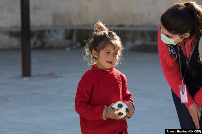 Naya, 4, is seen playing with a ball while talking to a UNICEF partner on Feb. 20, 2023, during a psychosocial activity in a shelter in Stamo village, located in Lattakia governorate in Syria. (Photo courtesy of UNICEF)