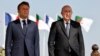 FILE— French President Emmanuel Macron (L) stands next to Algeria's President Abdelmadjid Tebboune (R) at Algiers airport, in Algiers, on August 27, 2022.