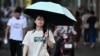 A woman walks during a hot day in Wuhan, central China's Hubei province, on Aug. 1, 2024.