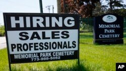 A hiring sign is displayed at a cemetery in Skokie, Illinois, May 10, 2023. 