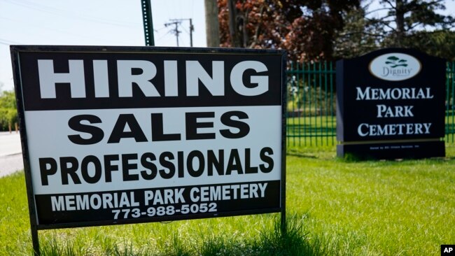 A hiring sign is displayed at a cemetery in Skokie, Illinois, May 10, 2023.