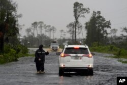 A man walks through storm surge on the flooded road into Horseshoe Beach, Florida, Aug. 5, 2024. Hurricane Debby made landfall early this morning.