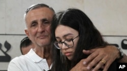 Freed Israeli hostage Noa Argamani, right, hugs her father Yakov, at the funeral for his wife and her mother Liora Argamani, in Beersheba, Israel, July 2, 2024.