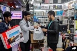 FILE - Customers buy computers and other digital accessories at a computer market in Dhaka, Bangladesh, Jan. 1, 2024. Recent high inflation has seriously slowed demand and consumption in the country.