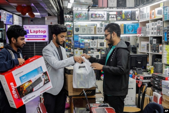 FILE - Customers buy computers and other digital accessories at a computer market in Dhaka, Bangladesh, Jan. 1, 2024. Recent high inflation has seriously slowed demand and consumption in the country.