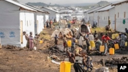 FILE - People displaced by fighting between Congolese forces and M23 rebels gather in a camp on the outskirts of Goma, Democratic Republic of the Congo, March 13, 2024. Fighting in part of eastern Democratic Republic of Congo has displaced over 100,000 people in the last week.