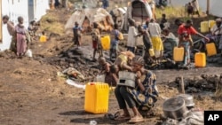 FILE - People displaced by fighting between Congolese forces and M23 rebels gather in a camp on the outskirts of Goma, Democratic Republic of the Congo, March 13, 2024.