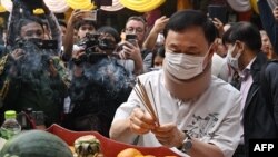 Mantan perdana menteri Thailand Thaksin Shinawatra memberikan penghormatan di kuil Buddha Wat Phra That Doi Suthep di Chiang Mai, 15 Maret 2024. (Lillian SUWANRUMPHA / AFP)