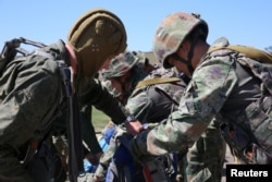 Service members take part in the 'Eagle Assault' joint military exercises of the armies of Belarus and China at an undisclosed location in Belarus, in this Belarusian Defense Ministry handout picture released July 9, 2024.