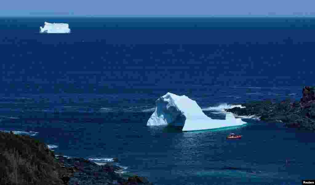 A tour boat is seen near icebergs that drifted south on the Labrador Sea from Greenland, in Saint Lunaire-Griquet, Newfoundland, Canada, May 27, 2024. 