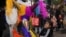 A child swings at a pinata during a street "posada" organized by neighbors in Mexico City, Dec. 22, 2023. 