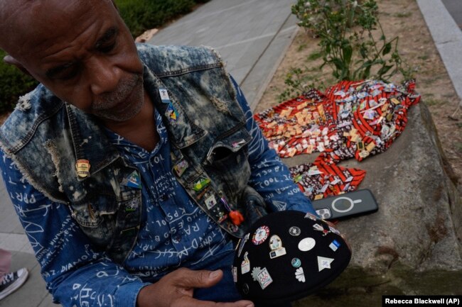 Thurston Bilal dari Los Angeles menunggu di luar Kampung Olimpiade untuk bertukar pin Olimpiade dengan atlet dan kolektor lainnya, di Olimpiade Musim Panas 2024, Selasa, 23 Juli 2024, di Paris, Prancis. (Foto: AP/Rebecca Blackwell)