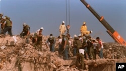 FILE - Rescue workers sift through the rubble of the U.S. Marine base in Beirut in Oct. 23, 1983, following a bomb blast that destroyed the base and killed 241 U.S. service members.