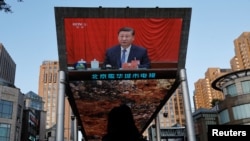 Sebuah layar televisi raksasa menayangan Presiden China Xi Jinping menghadiri rapat pleno ketiga Komite Pusat Partai Komunis China di Beijing, China, Kamis 18 Juli 2024. (Foto: Tingshu Wang/Reuters)