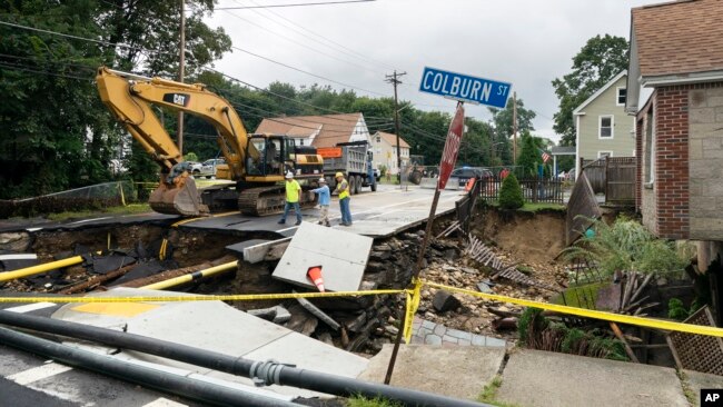 Cuadrillas de reparación examinan los daños en una calle después de inundaciones en Leomister, Massachusetts, EEUU el 13 de septiembre de 2023.