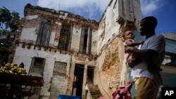 Residents walk past dilapidated mansion in Havana, Cuba, Oct. 5, 2023.