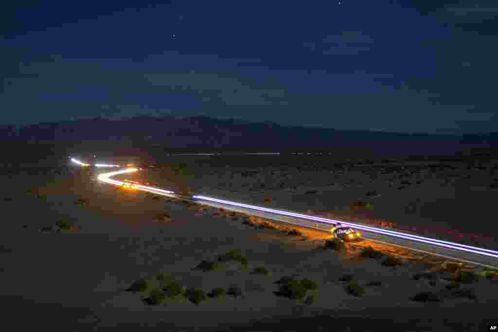 This long exposure image shows the path of runners and their support vehicles under a moon light sky on California Route 190 during the Badwater 135 mile (217 kilometer) ultramarathon in Death Valley, California, July 23, 2024. 