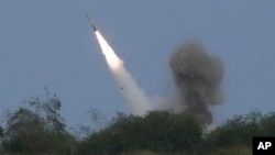 FILE — A U.S. M142 High Mobility Artillery Rocket System (HIMARS) fires a missile during a joint military exercise at a naval station in the Philippines, April 26, 2023. The U.S. is providing more military aid for Ukraine in a package that includes more rockets for HIMARS.