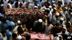 Relatives and mourners gather around the caskets of victims who were killed in Sunday's suicide bomber attack in the Bajur district of Khyber Pakhtunkhwa, Pakistan, July 31, 2023.