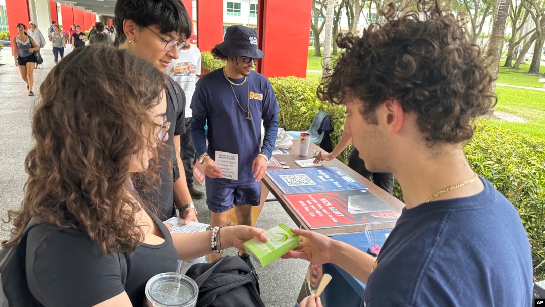 FILE - College students pass out literature to educate young voters at Florida Atlantic University, in Boca Raton, Florida, April 11, 2024.