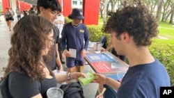 FILE - College students pass out literature to educate young voters at Florida Atlantic University, in Boca Raton, Florida, April 11, 2024.